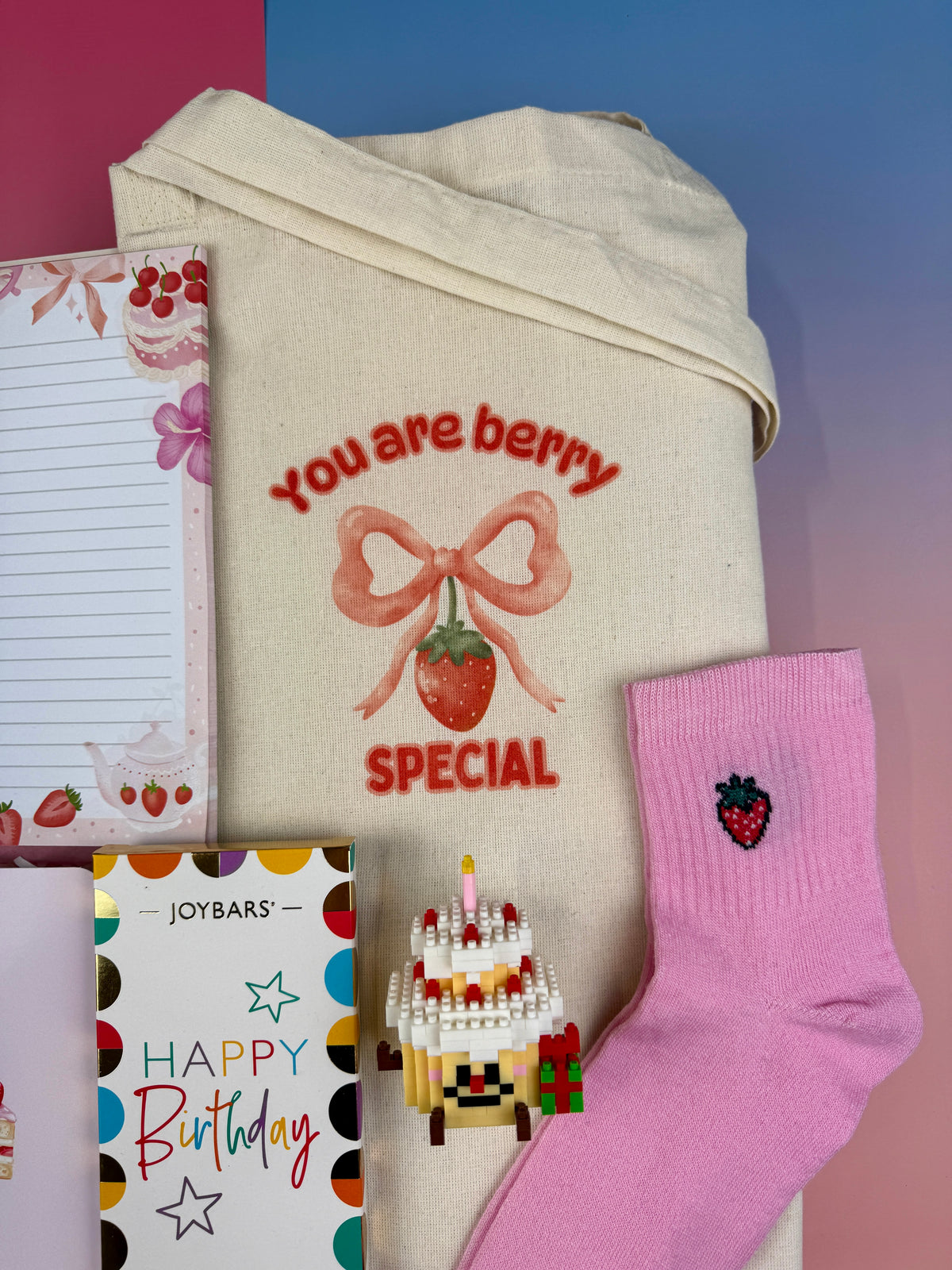 Natural cotton tote bag with You Are Berry Special strawberry and pink bow illustration and Pink strawberry embroidered socks and DIY miniature birthday cake building block kit