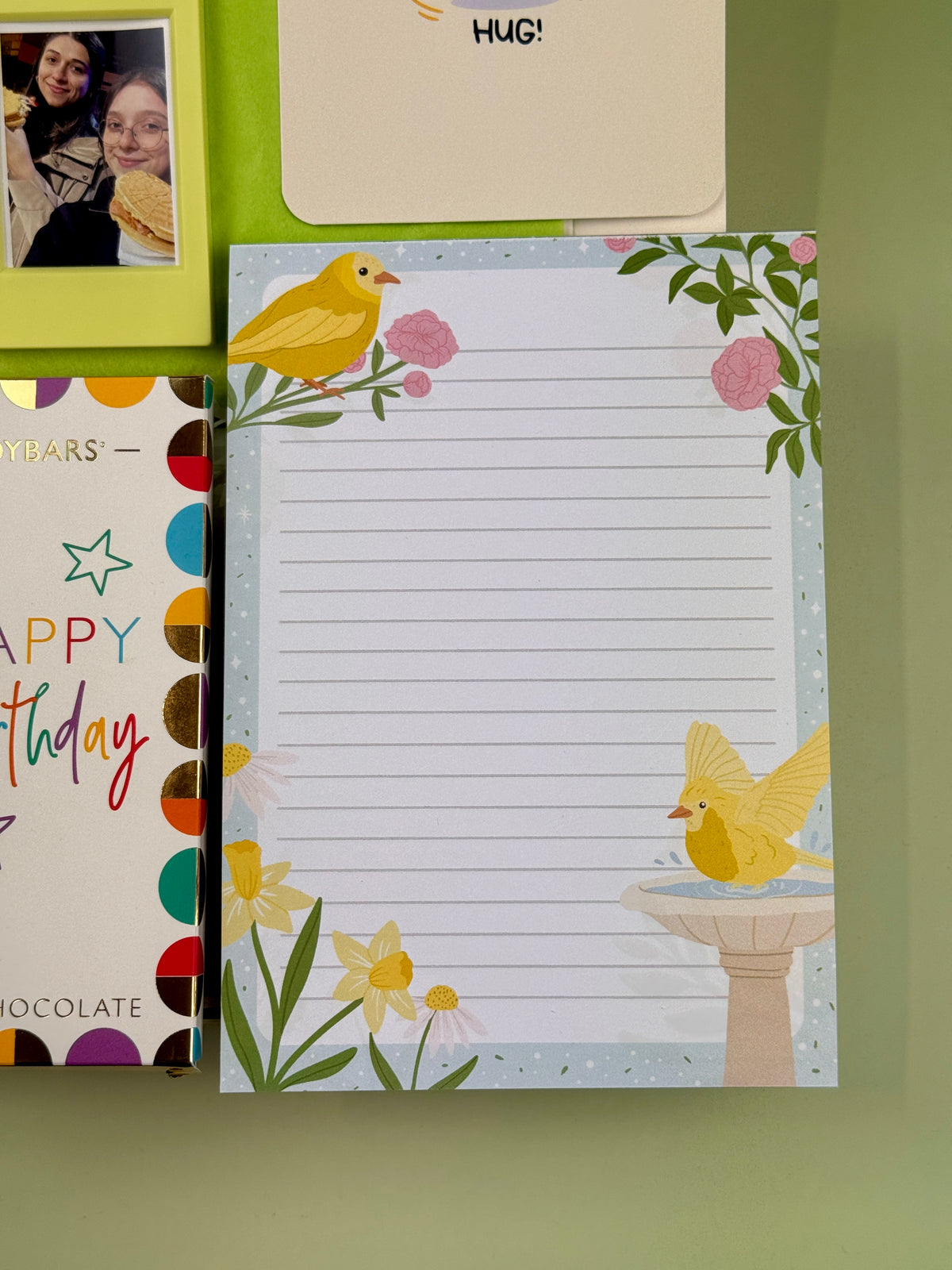 Spring-themed lined notepad featuring yellow birds, pink flowers and daffodils, part of a birthday gift box
