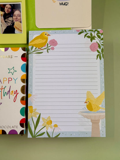 Spring-themed lined notepad featuring yellow birds, pink flowers and daffodils, part of a birthday gift box